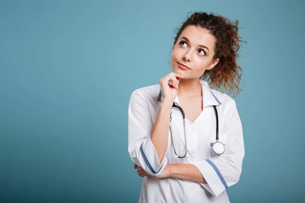 Portret van een serieuze jonge verpleegster denken en op zoek weg — Stockfoto