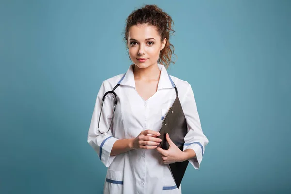 Sorrindo jovem enfermeira médica de uniforme segurando prancheta — Fotografia de Stock