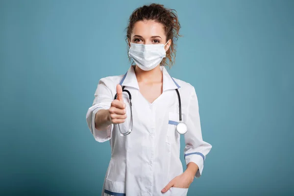 Portret van een vrouwelijke arts of verpleegkundige chirurgisch masker te dragen — Stockfoto