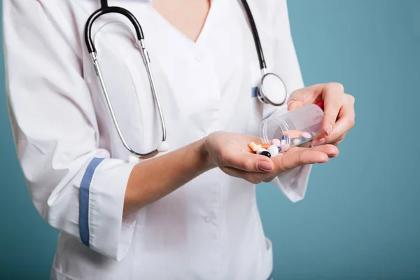 Verpleegkundige gieten pillen in hand geïsoleerd — Stockfoto