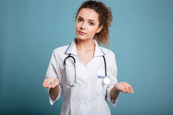 Infirmière femme offrant le choix entre les pilules dans sa main — Photo