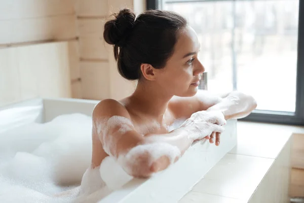 Nachdenkliche junge Frau sitzt und denkt in Badewanne — Stockfoto