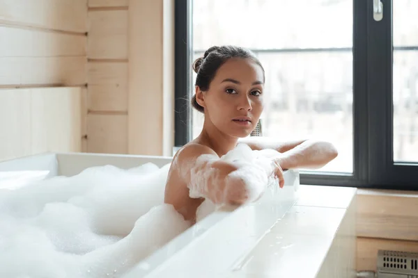 Hermosa mujer joven en bañera con espuma — Foto de Stock