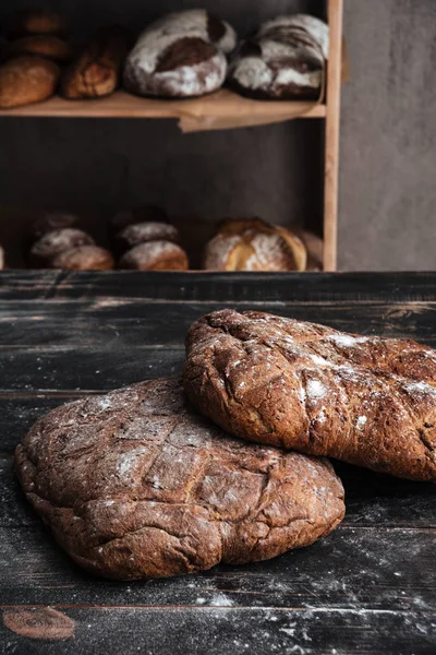 Pain avec farine sur table en bois foncé à la boulangerie — Photo