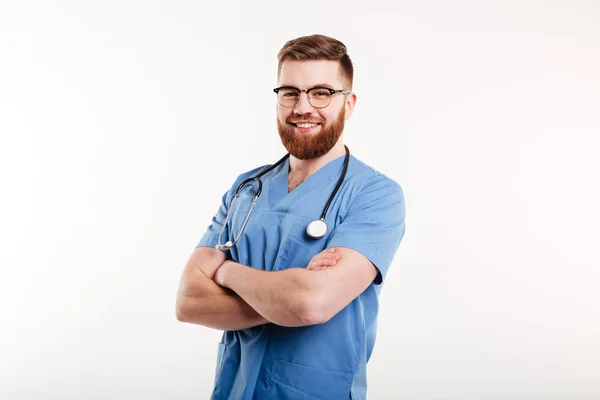Portrait of a smiling male doctor standing with arms folded — Stock Photo, Image