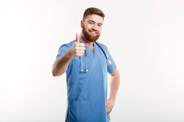 Porträtt av en ung vänlig man läkare med stetoskop visar — Stockfoto