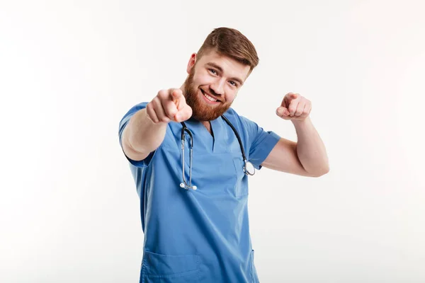 Jovem animado médico masculino apontando dois dedos para a câmera — Fotografia de Stock