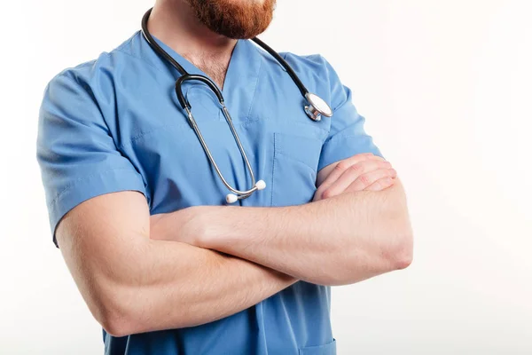 Ung manlig läkare med stetoskop står med händerna vikas — Stockfoto