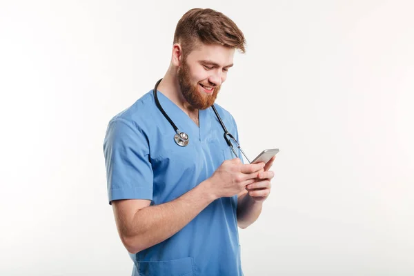 Portrét muže lékaře se stetoskopem pomocí smartphonu. — Stock fotografie