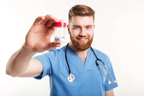 Retrato de um médico segurando uma garrafa com comprimidos — Fotografia de Stock