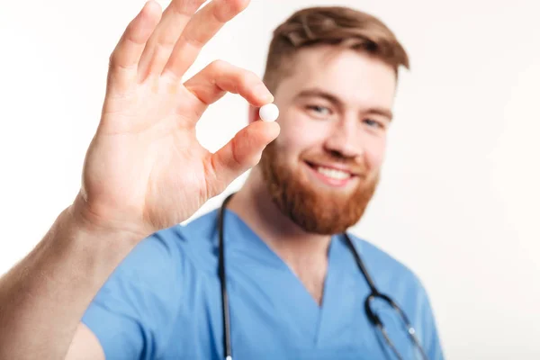 Portret van een jonge mannelijke arts het aanbieden van een pil — Stockfoto