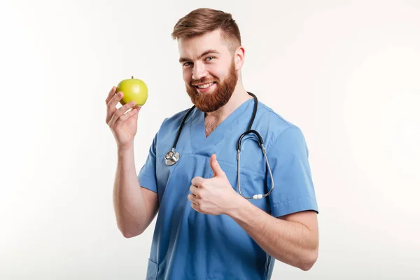 Porträt eines gut aussehenden Arztes im blauen Mantel, der in die Kamera blickt — Stockfoto