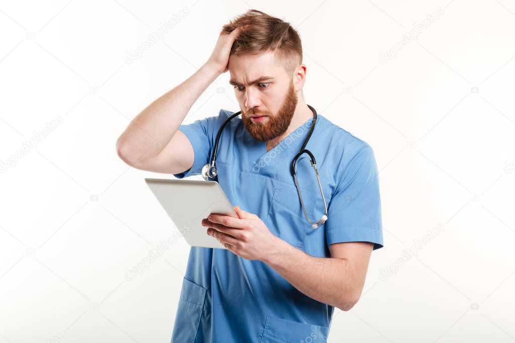 Portrait of a surprised young doctor in blue uniform