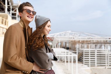 Çift ayakta ve sahilde sonbaharda sarılma