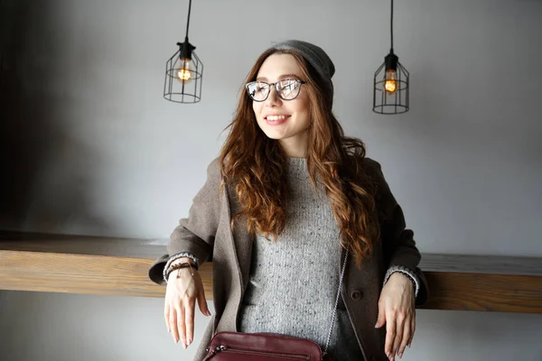 Jovem mulher atraente alegre sentado e olhando para longe no café — Fotografia de Stock