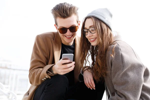 Paar via mobiele telefoon samen op het strand in de herfst — Stockfoto