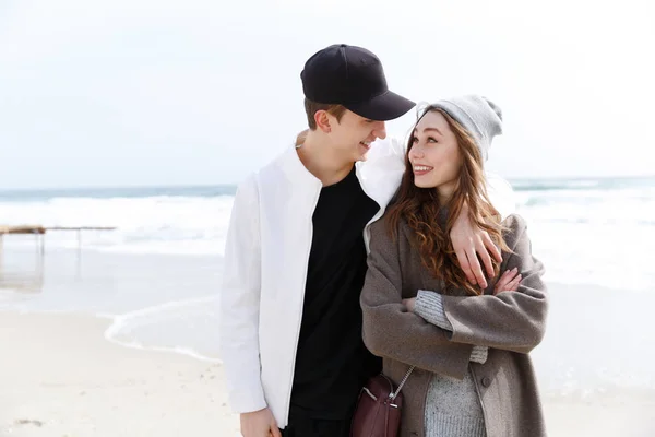 Весной счастливая молодая пара обнимается на пляже — стоковое фото