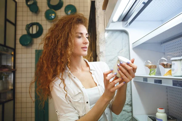 Hübsche rothaarige junge Dame steht im Café und wählt Dessert — Stockfoto