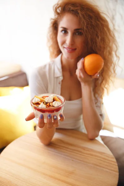 Bella rossa giovane signora in caffè con dessert e agrumi . — Foto Stock