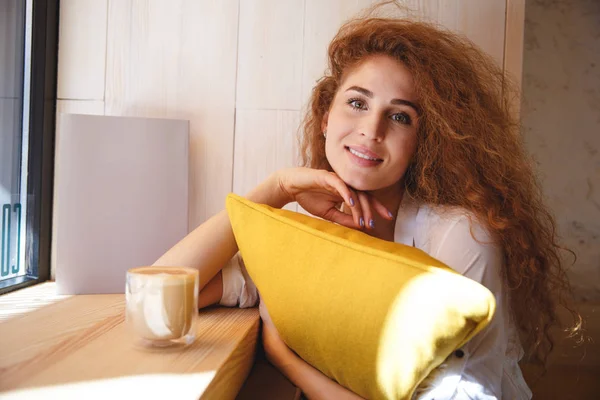 Retrato de uma adorável jovem mulher ruiva abraçando travesseiro — Fotografia de Stock