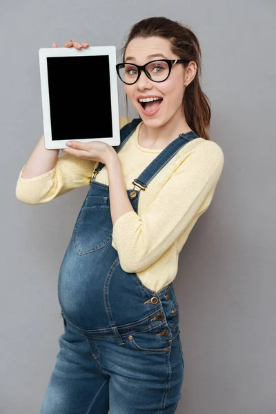 Senhora feliz grávida mostrando exibição de computador tablet . — Fotografia de Stock