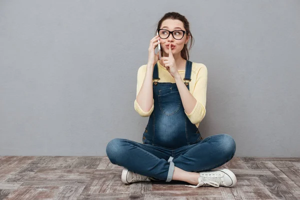 Mulher grávida conversando por telefone celular e fazer gesto de silêncio . — Fotografia de Stock