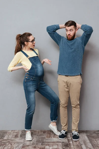 Kobieta w ciąży poważne patrząc na mylić mężczyzna. — Zdjęcie stockowe