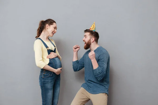 Porträtt av ett glatt ungt par firar graviditet — Stockfoto