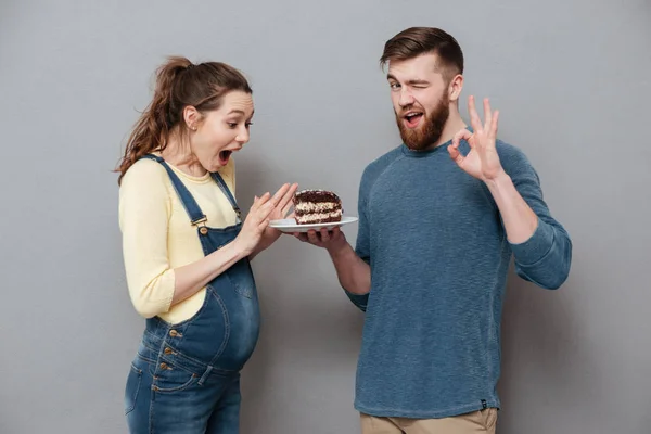 Man ger plattan med chocolae tårta till sin gravida hustru — Stockfoto