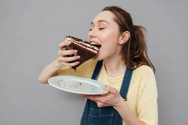 Wanita hamil muda yang lapar akan makan kue coklat — Stok Foto