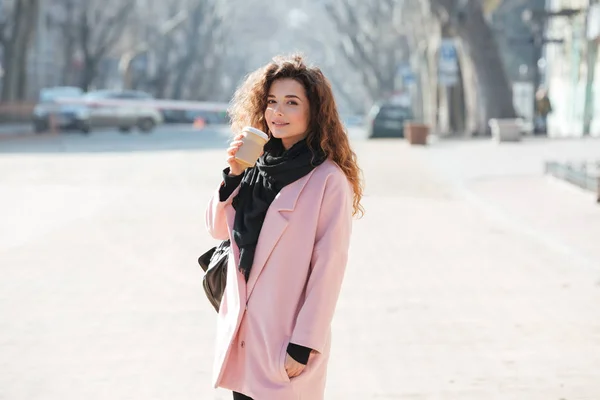 Güneşli şehirde sokak yürüyüş pembe ceket giyen kadın. — Stok fotoğraf