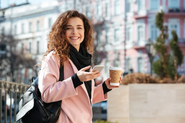 Retrato de una linda mujer joven usando el teléfono celular en la calle . —  Fotos de Stock