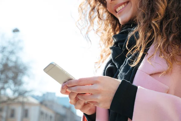 Immagine ritagliata di donna sorridente utilizzando smartphone — Foto Stock