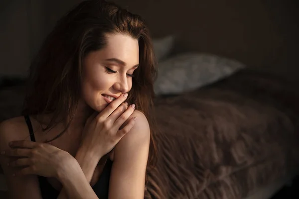 Şehvetli güzel genç kadın evde yatak odasında oturuyordu — Stok fotoğraf