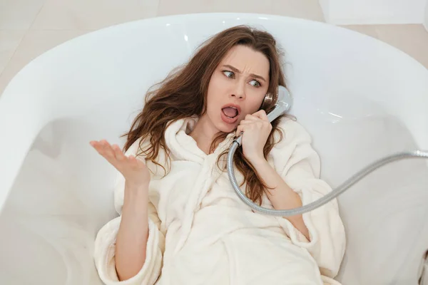Oynak kadın duş küvet kullanarak telefon alarak taklit çatık — Stok fotoğraf