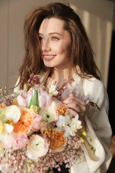 Mujer feliz de pie y la celebración de ramo de flores en casa — Foto de Stock