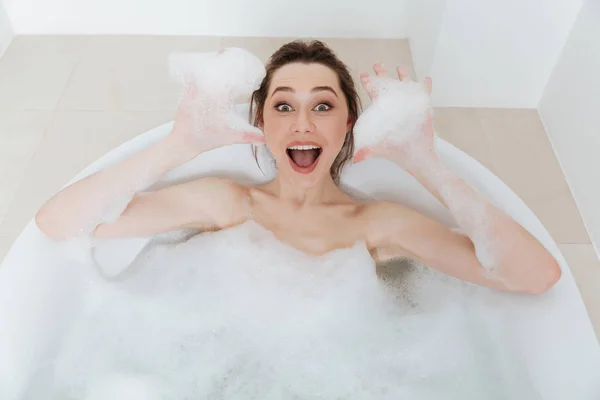 Jovem animada alegre se divertindo na banheira com espuma — Fotografia de Stock