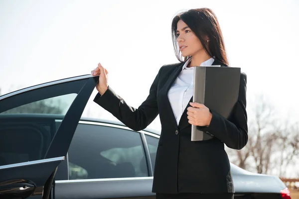 Affärskvinna hålla mappen står nära bilen — Stockfoto