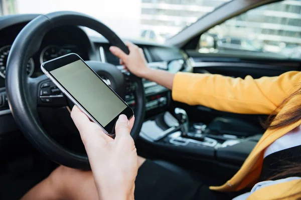 Close up image with female driver and blank phone screen — Stock Photo, Image