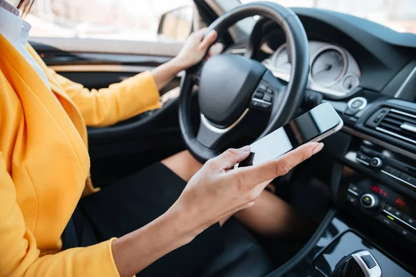 Ung kvinna drivrutinen med hjälp av touch skärm smartphone — Stockfoto