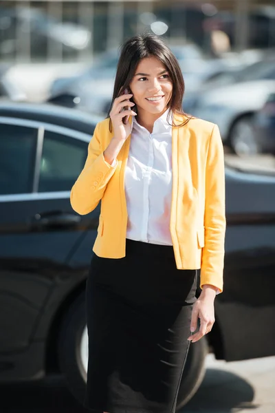 Деловая женщина в умной одежде разговаривает по мобильному телефону на улице — стоковое фото