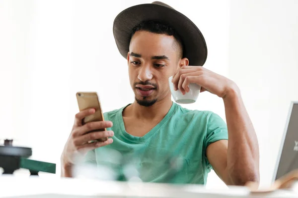 African man in t-shirt using smartphone — Stock Photo, Image