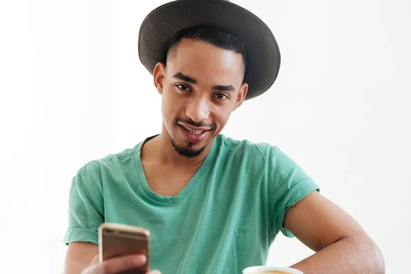 Smiling man in t-shirt holding smartphone — Stock Photo, Image