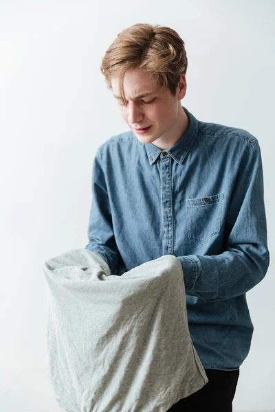 Imagen vertical del joven sosteniendo la camiseta — Foto de Stock