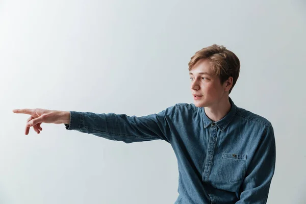 Lächelnder junger Mann zeigt weg — Stockfoto