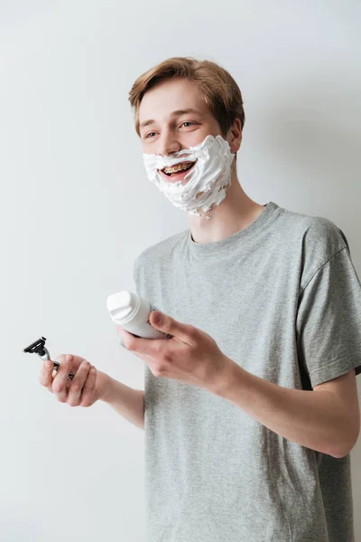 Vertical image of happy man in shaving foam holding razor — Stock Photo, Image