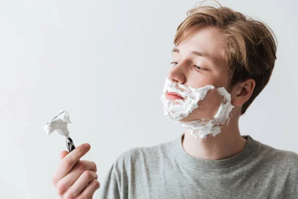Detail portrét mladého muže v držení břitva pěna na holení — Stock fotografie