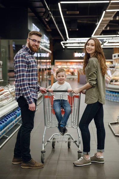 Imagen vertical de padres con hijo en carrito de la compra — Foto de Stock