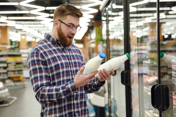 Sorprendido hombre feliz eligiendo la leche —  Fotos de Stock