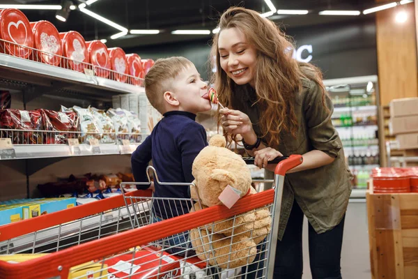 Giovane madre che dà caramelle a suo figlio — Foto Stock